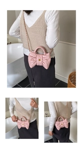 Détail du sac à main matelassé rose en forme de nœud avec fermoir fleur dorée et chaîne