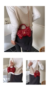Détail du sac à main rouge matelassé avec nœud, fermoir fleur dorée et chaîne