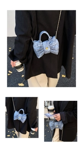 Détail du sac noeud en denim bleu clair avec surpiqûres en losange et bouton camélia doré