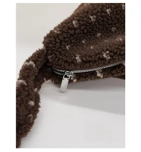 Détail du sac cabas en peluche marron montrant la texture sherpa et la fermeture éclair argent