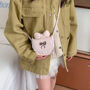 Pink girls crossbody bag with 3D bow and lace trim, worn by child model