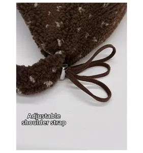Détail macro de la bandoulière réglable brune avec boucle en métal sur sac cabas