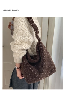 Sac fourre-tout en peluche à pois porté par un mannequin en pull à torsades et jupe