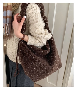 Détail d'un sac cabas marron en peluche à pois blancs pour les tenues d'hiver chic