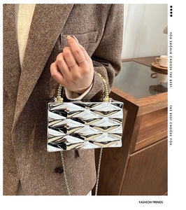Modern silver acrylic box clutch with geometric texture and gold spiral handle