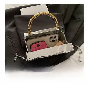 Mirror silver acrylic box clutch with gold bead handle showing internal storage capacity