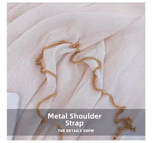 Detail of high-quality polished gold metal chain strap on textured beige fabric