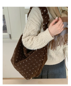 Sac fourre-tout en polaire marron à pois blancs porté par un mannequin pour le style