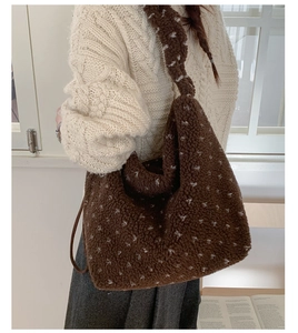 Gros plan du sac cabas marron en laine d'agneau avec pois sur un pull en maille