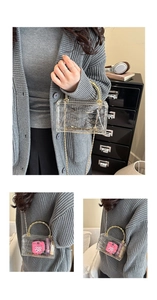 Detail of transparent acrylic box bag with gold bamboo handle and chain strap