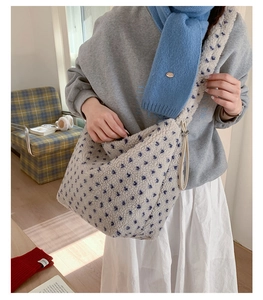 Détail du cabas en peluche crème avec motifs étoiles bleues et cordon de serrage latéral