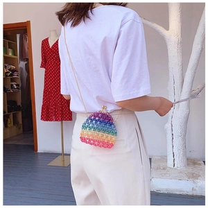 Rainbow beaded mini evening bag with gold chain strap shown on person back view