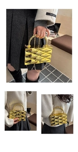 Detailed view of the gold acrylic box clutch featuring geometric wavy facets and chain