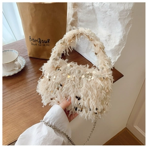 Close-up of fluffy faux fur bucket bag with sparkling gold sequins and silver chain strap