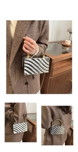 Detail of acrylic clutch box bag with wavy metallic texture and chain strap