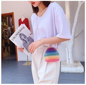 Rainbow acrylic beaded bag with vintage gold metal clasp and chain strap worn by a model