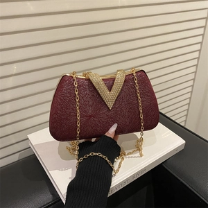Elegant burgundy evening clutch with V-shaped diamond buckle and gold chain strap