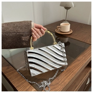 Silver wave-textured acrylic box clutch with golden spiral handle and metal chain