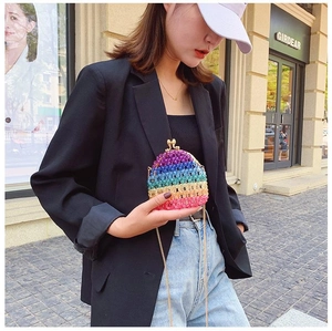 Close-up of rainbow acrylic beaded mini bag with gold chain strap in street style