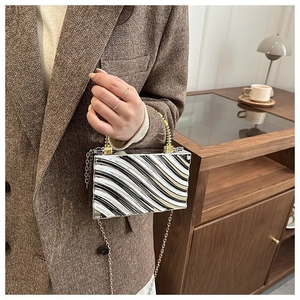 Silver wavy acrylic box bag with gold metal handle and chain strap for parties