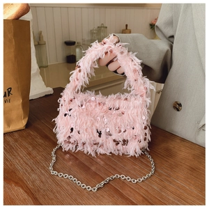 Close-up of pink feather bucket bag with sparkling sequins and silver metal chain strap