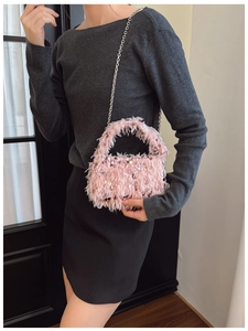 Detail of pink feather handbag with sequins and silver chain strap worn by a model