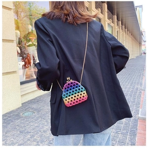 Rainbow acrylic beaded mini bag with gold chain strap worn over a black blazer