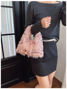 Detailed shot of pink faux fur handbag with shimmering sequins and sleek top handle design