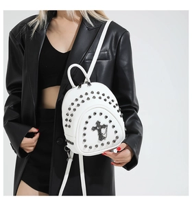 Détail du mini sac à dos blanc style punk avec rivets argentés et emblème de croix