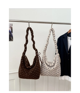 Détail des sacs fourre-tout en laine d'agneau à pois en marron et blanc sur support