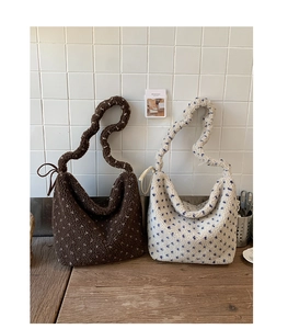 Gros plan de sacs cabas en peluche à pois marron et crème sur une surface en bois