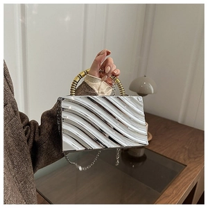 Detail of silver wavy acrylic clutch bag with gold spiral handle and chain strap