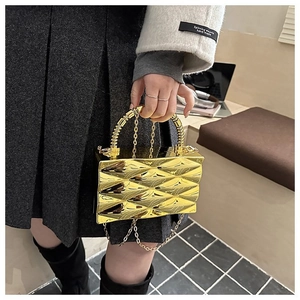 Detail of gold geometric acrylic box bag with 3D diamond texture and metal handle