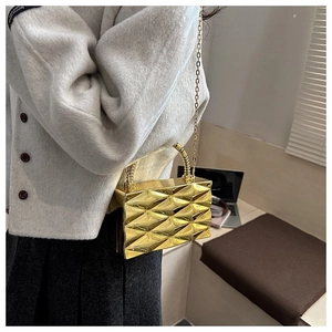 Detail of a 3D geometric acrylic gold mirror clutch bag with its elegant metal chain strap