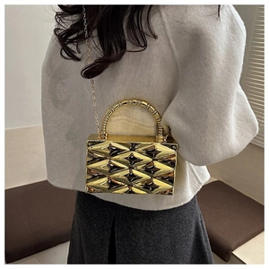 Detail of gold metallic crossbody bag with 3D diamond texture and bead handle strap
