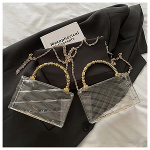 Detail of transparent acrylic box bags with gold bead handles and chain straps