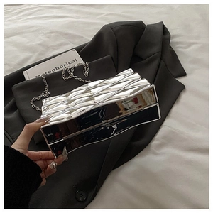 Detail of silver geometric acrylic box evening clutch with metallic finish and chain