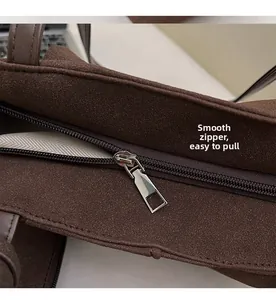 Detail of smooth metal zipper and herringbone lining on brown suede tote bag