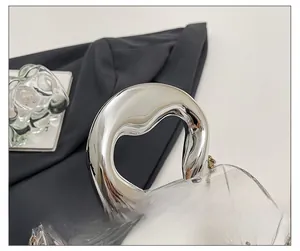 Détail du sac boîte en acrylique transparent avec poignée argentée et bandoulière chaîne