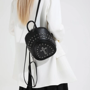Gothic black mini backpack with silver rivets and cross pendant for women on white suit