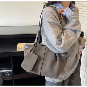 Detail of dark grey suede tote bag with matching small pouch and side buckle strap