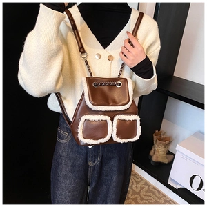 Detail of a brown faux leather backpack with white plush faux fur trim and chain drawstring