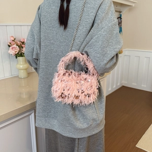 Elegant pink plush bucket bag with sequins and silver chain strap shown on model