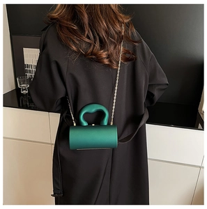 Vue arrière d'un sac à bandoulière cylindrique vert avec poignée épaisse et chaîne