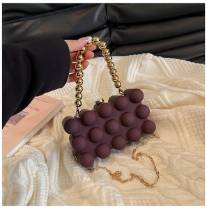 Detailed view of the 3D bubble texture on the brown acrylic evening clutch bag