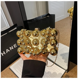 Detailed view of egg-shaped evening bag with gold metallic spheres and chain strap