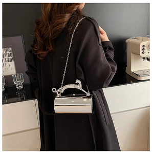 Silver cylindrical clutch with leopard handle and chain strap on female model