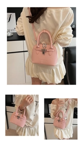 Detailansicht der rosa Handtasche mit Litschi-Muster, Metalldrehverschluss und Schultergurt