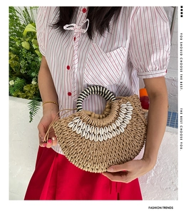 Detail of handmade straw bag with shell decor and striped handle for beach fashion