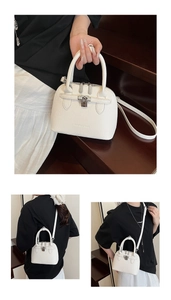 Detailansicht der weißen Handtasche aus Litschi-Leder mit silberner Schnalle und Gurt